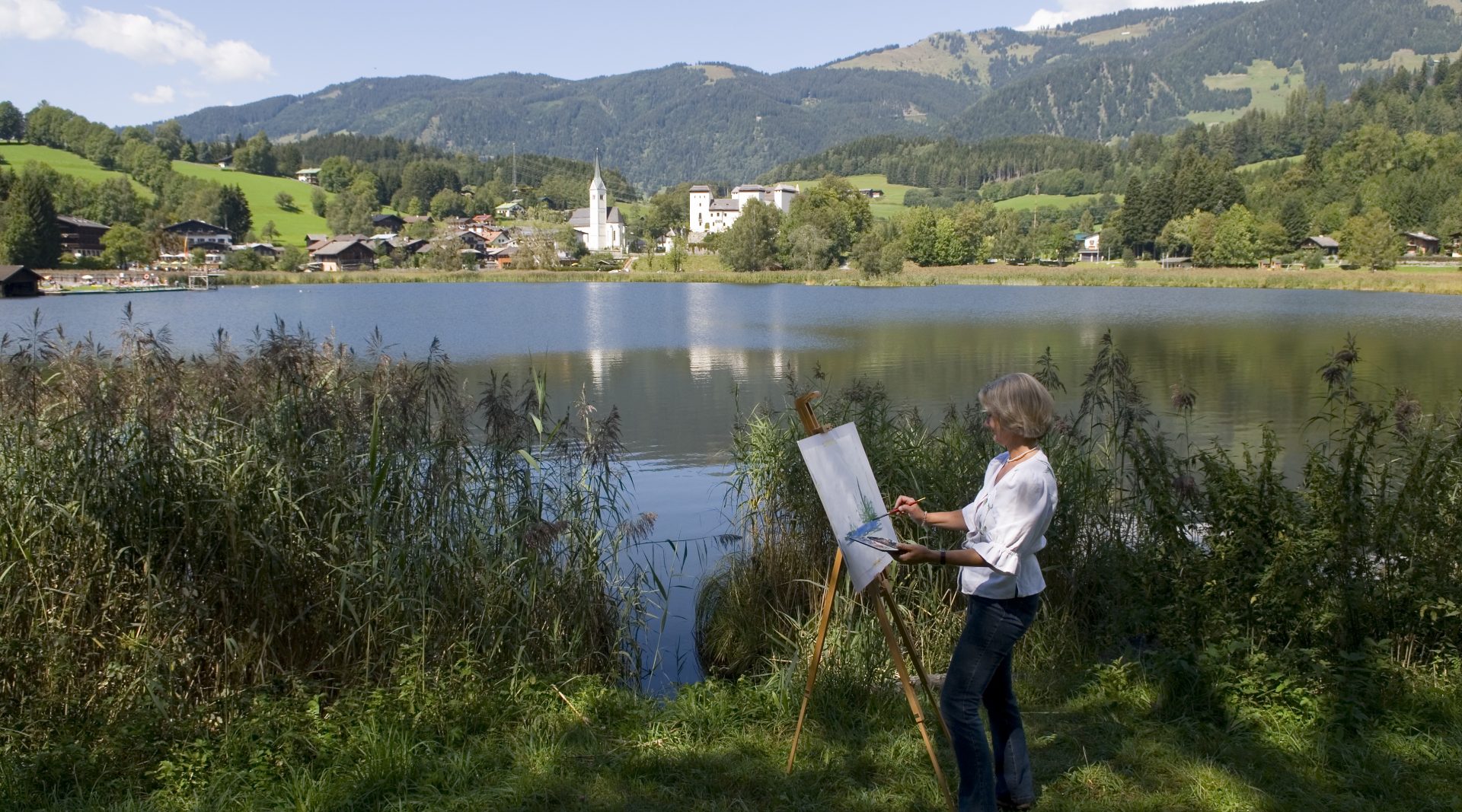 Eine Frau steht am Moorsee und malt