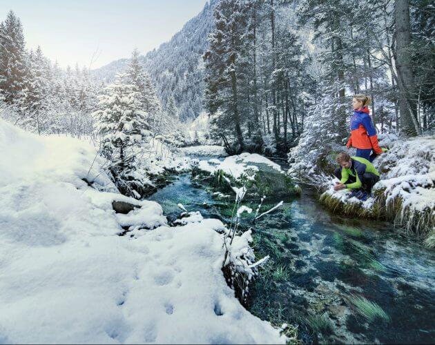 AGS, Gesundheit, Pärchen am Bach Zwei Läufer erfrischen sich am glasklaren Bach in einem verschneiten Wald