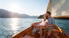 Paar genießt die Sonne beim Segeln vom Boot aus.