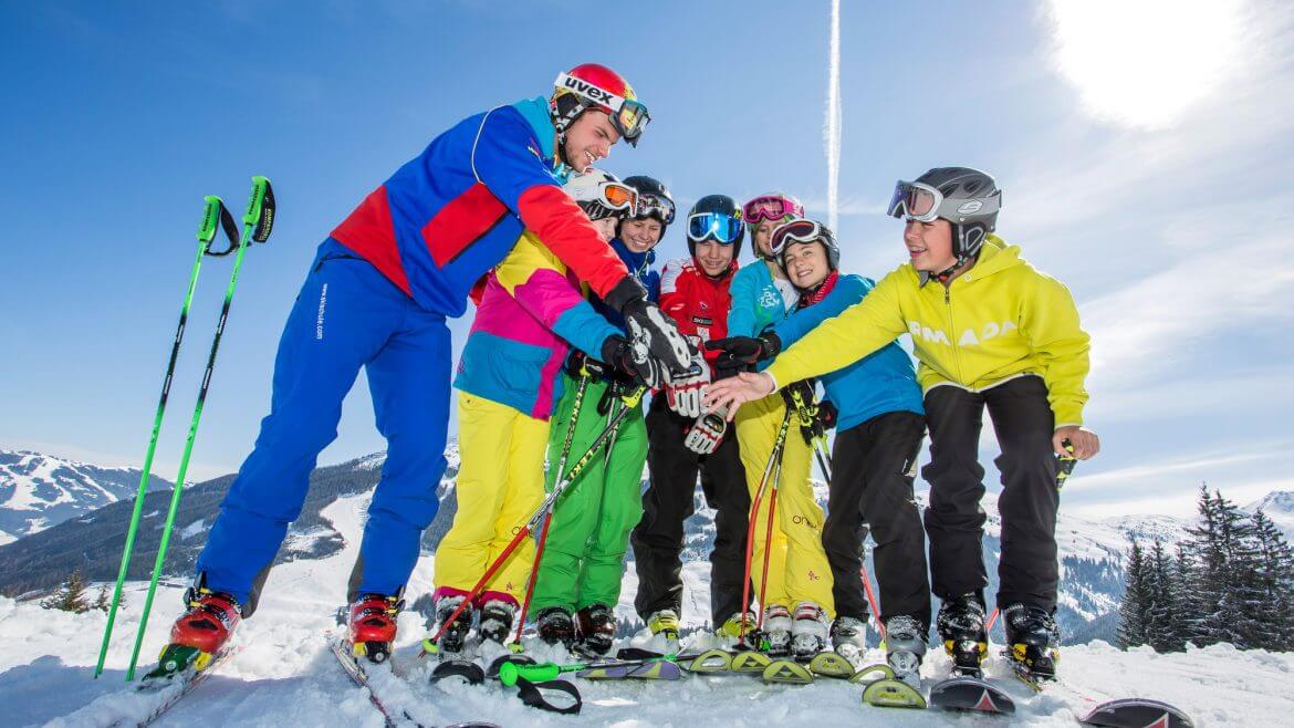 Eine Skikurs-Gruppe reicht sich die Hände