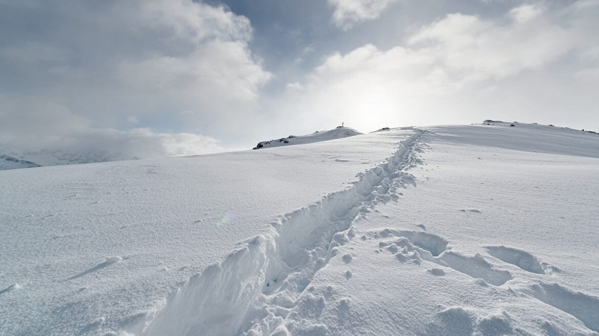 Eine Spur zieht sich durch den frischen Tiefschnee