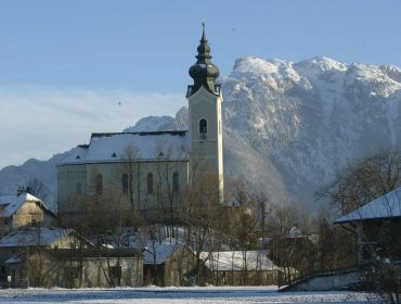 Die Schnee bedeckte Kirche von Wals-Siezenheim - im Hintergrund der Untersberg