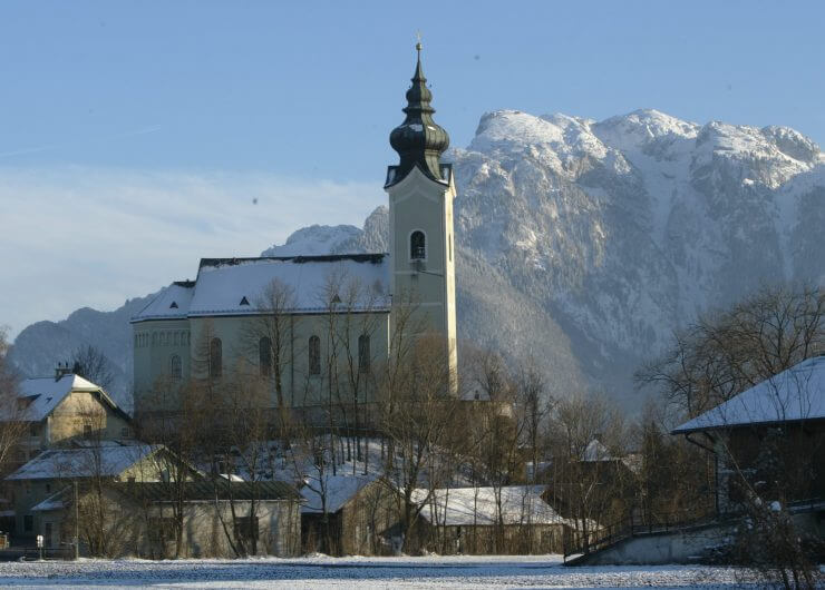 Die Schnee bedeckte Kirche von Wals-Siezenheim - im Hintergrund der Untersberg