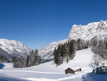 Verschneiter Stadl vor prächtiger Winterkulisse
