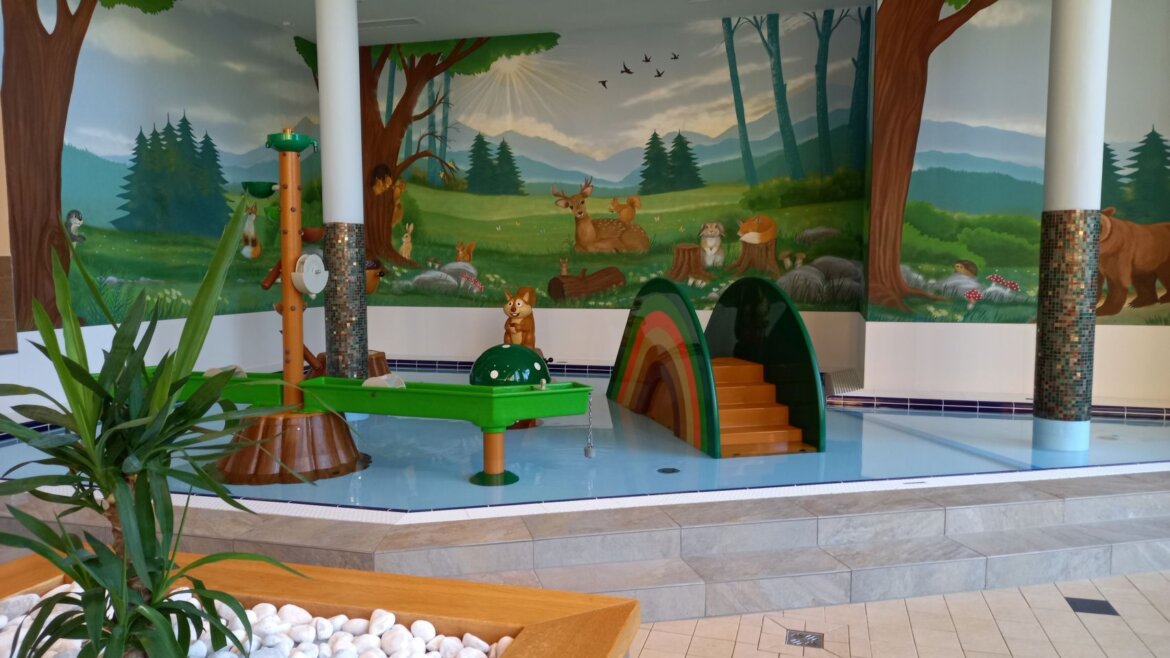(c) Aqua Salza Indoor-Kinderspielbereich im Aqua Salza mit tierischen Strukturen und einem Wald-Wandbild. (vergrößerte Ansicht)