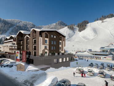 Modernes Hotel und Skigebiet am Fuße der verschneiten Berge mit Skiliften und parkenden Autos im Winter.