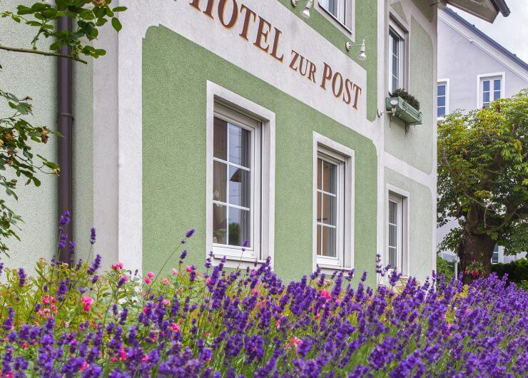 Hausfassade des Hotels zur Post mit blühendem Lavendel im Vordergrund