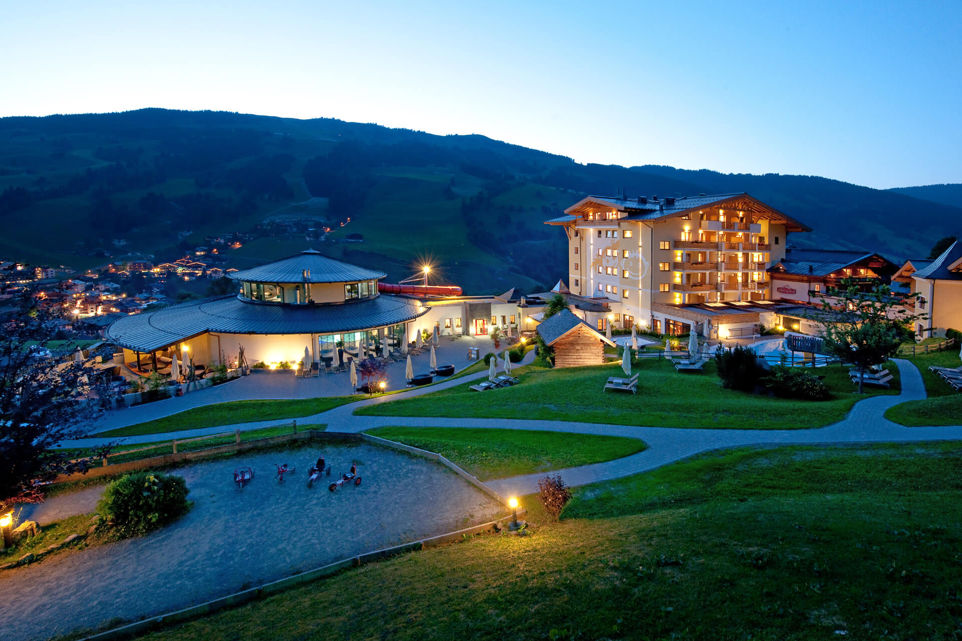 Die Hotelanlage des Ellmauhofes in der Abenddämmerung, Sommer