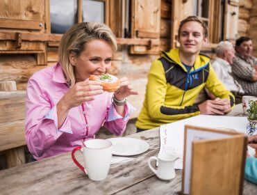 © SalzburgerLand Tourismus, Michael Größinger, Alexandra Meissnitzer beim Krapfenessen auf der Gainschniggalm