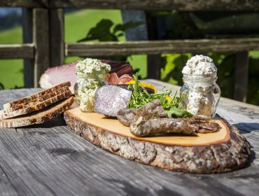 Jause am Holzbrett serviert mit Wurst, Speck und Brot