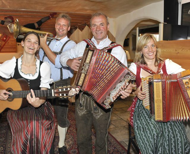 Volksmusikgruppe spielt in Almhütte