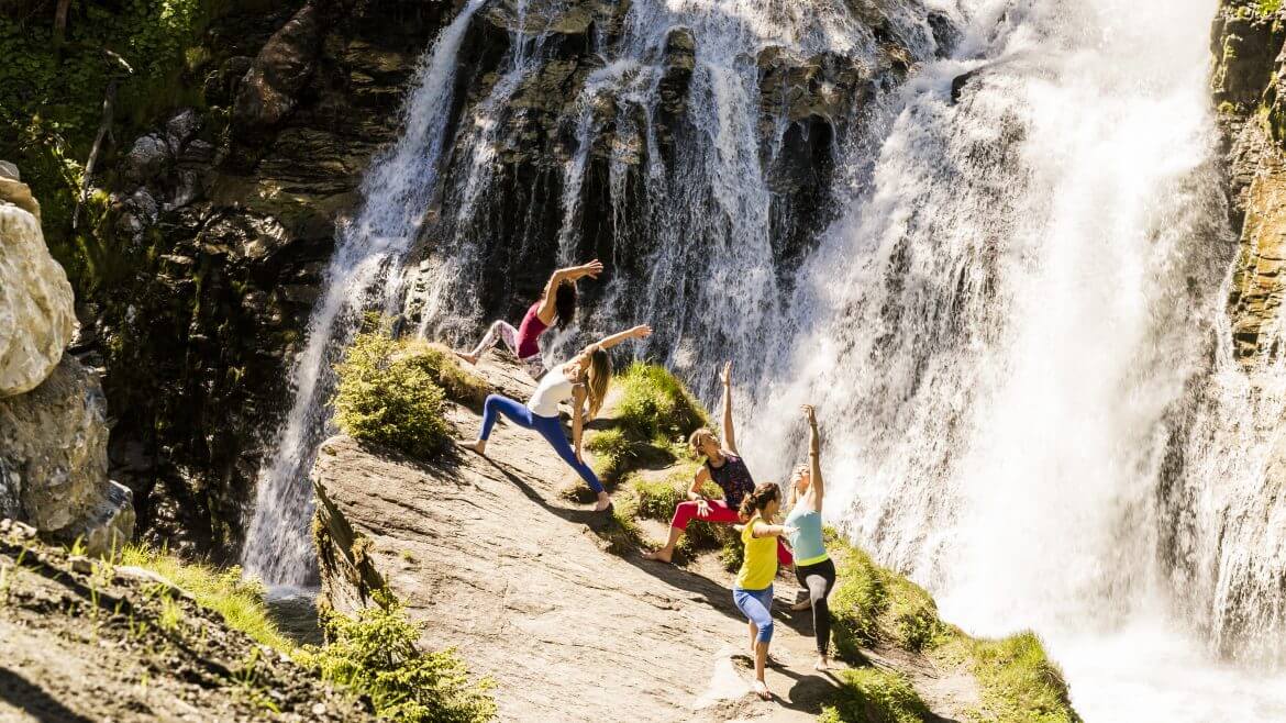 AGS, Gesundheit, Kur- und Gesundheitspartner Gastein, Yoga am Wasserfall Eine Gruppe macht Yoga am Wasserfall
