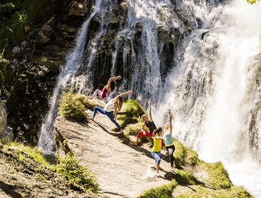 AGS, Gesundheit, Kur- und Gesundheitspartner Gastein, Yoga am Wasserfall Eine Gruppe macht Yoga am Wasserfall
