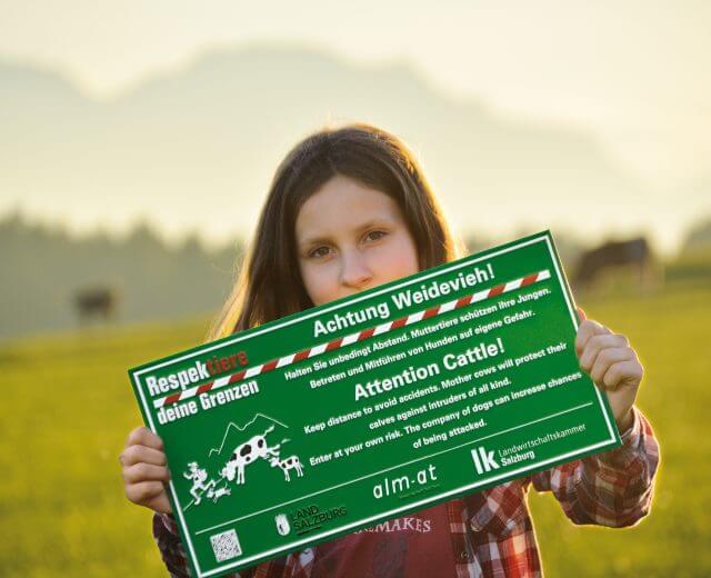 Mädchen mit Schild Achtung Weidevieh