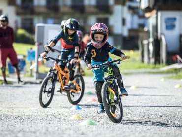 Kinder mit Helm am Mountainbike im Bikepark