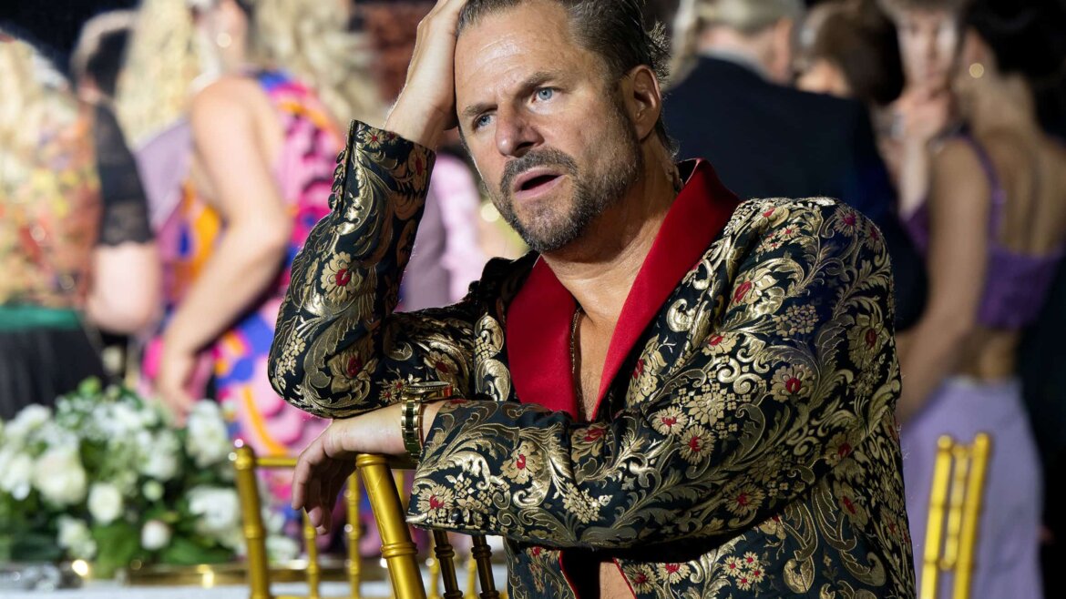 Jedermann in einem gemusterten Anzug sitzt nachdenklich auf einem goldenen Stuhl und erinnert an die Atmosphäre von „Jedermann“ bei den Salzburger Festspielen.