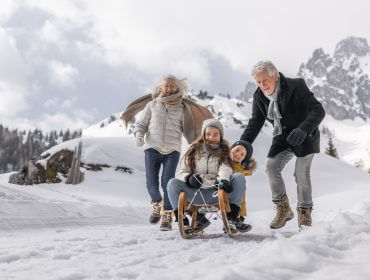 Oma und Opa mit Enkeln beim Rodeln, Generationen Wintertag Filzmoos (c)SLTG, Michael Groessinger