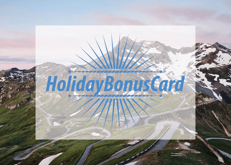 Kurvenreiche Bergstraße mit schneebedeckten Gipfeln, überlagert von HolidayBonusCard in blauer Schrift und einem Sonnenschliffmuster.