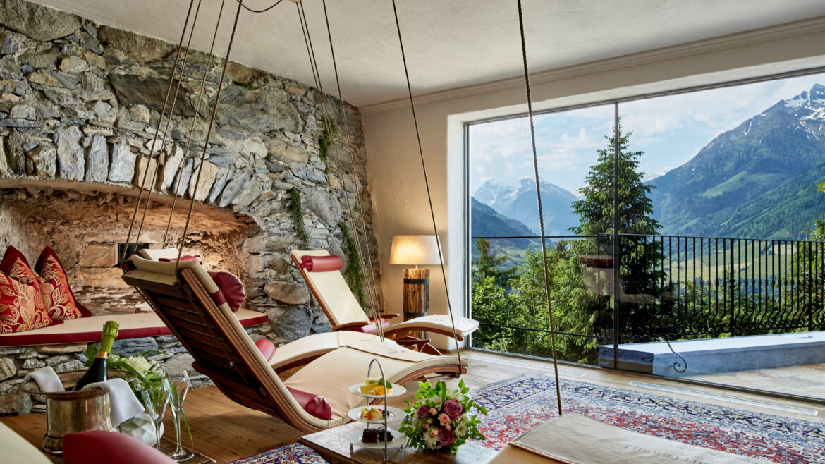 Ruheraum © Schloss Mittersill Gemütliche Lounge im Schloss Mittersill mit Hängesesseln, Bergblick und einer rustikalen Steinwand mit Kissen. (vergrößerte Ansicht)