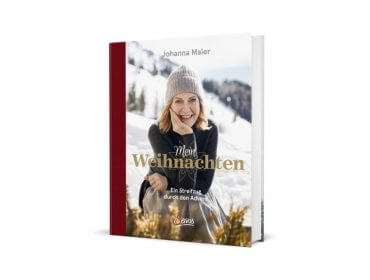 Buchumschlag mit einer lächelnden Frau in Winterkleidung in verschneiten Bergen, mit dem Titel Mein Weihnachten von Johanna Maier.