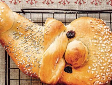 Süßes Brot in Form eines Weihnachtsmannes mit Zucker und Rosinen auf einem Kühlregal, daneben eine Schale mit Erdnüssen.
