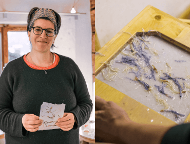 Eine Person hält handgeschöpftes Papier mit getrockneten Blumen in der Hand; Hände rahmen weiteres Blumenpapier auf einer Holzform ein.