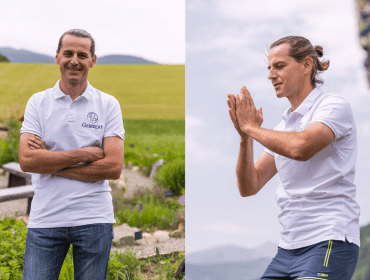 life-coach-manfred-vom-gratzgut Ein Mann in einem weißen Polohemd steht auf einem Feld und faltet im Freien seine Hände zusammen.