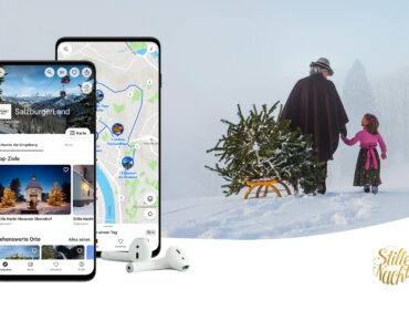 Zwei Telefone zeigen eine Reise-App an; daneben ziehen ein Kind und ein Erwachsener einen Weihnachtsbaum einen verschneiten Hügel hinauf.