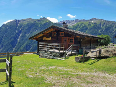Almhütte aus Holz vor Bergpanorama