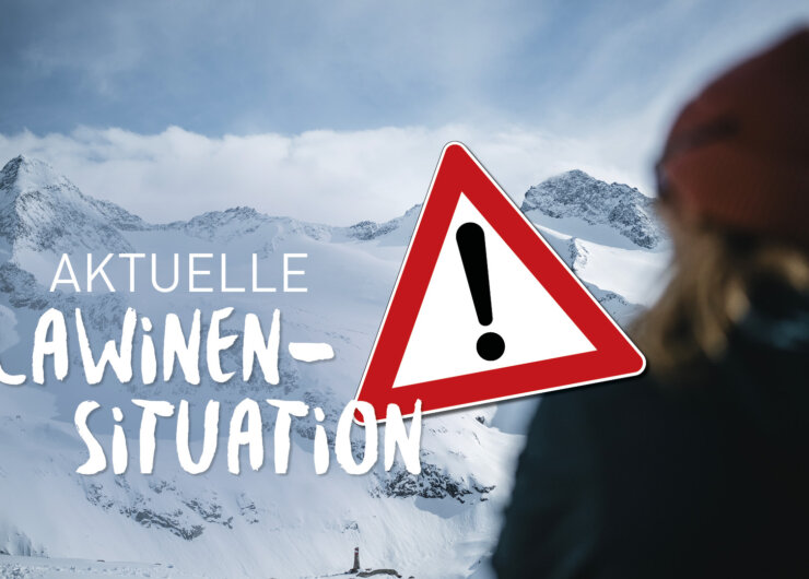 Person blickt auf verschneite Berge mit deutschem Text Aktuelle Lawinensituation und einem Lawinenwarnschild.