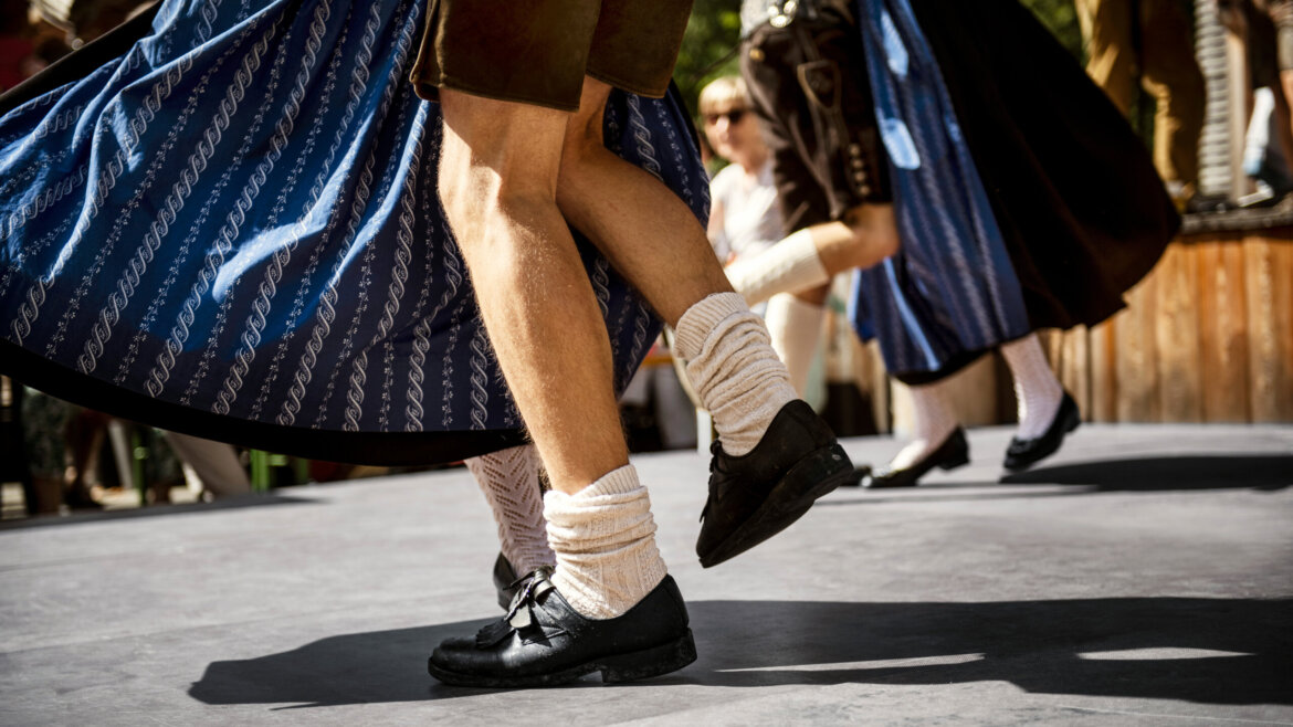 © SalzburgerLand Tourismus, Markus Berger, Bauernherbst Tanz Menschen in traditioneller Kleidung tanzen im Freien; Nahaufnahme von sich bewegenden Beinen an einem sonnigen Tag. (vergrößerte Ansicht)