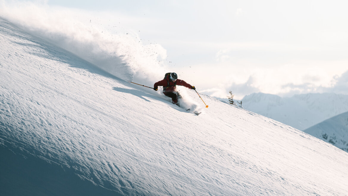 Saalbach Freeriden-c-saalbach.com, Moritz Ablinger A skier in red kit carves down a snowy mountain slope in Saalbach Hinterglemm under a clear sky. (Enlarged view)