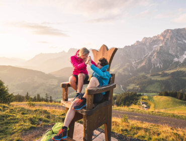 couple sitting on a wooden throne infront of beautiful mountain scernery