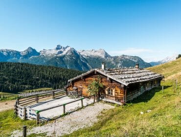 Pärchen sitzt vor der Almhütte.
