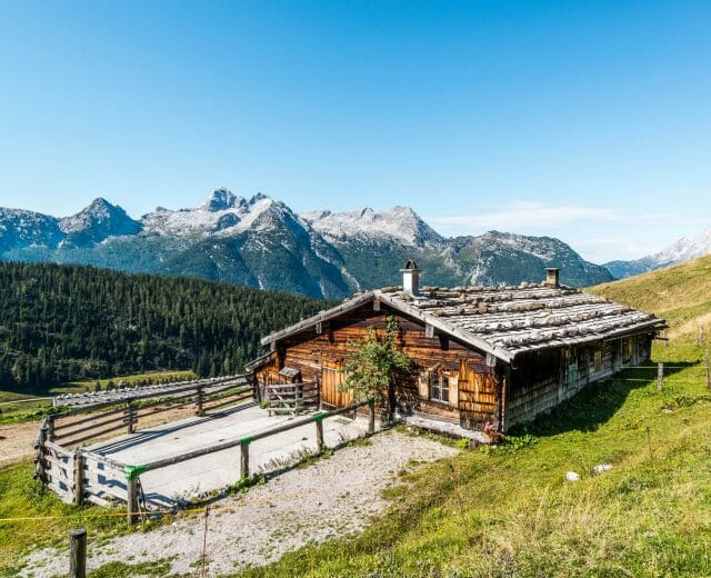 Pärchen sitzt vor der Almhütte.