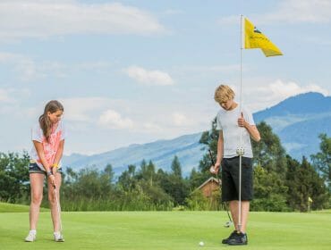 Zwei Jugendliche beim Golf am Putting Green