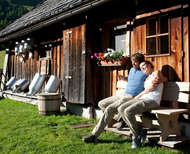 Pärchen sonnt sich vor bewirtschafteter Alm