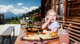 blonde girl enjoys her meal on a summer hut