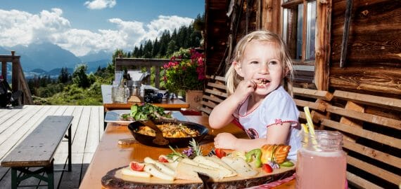 blonde girl enjoys her meal on a summer hut