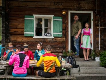 Gäste vor der Almhütte mit Wirt