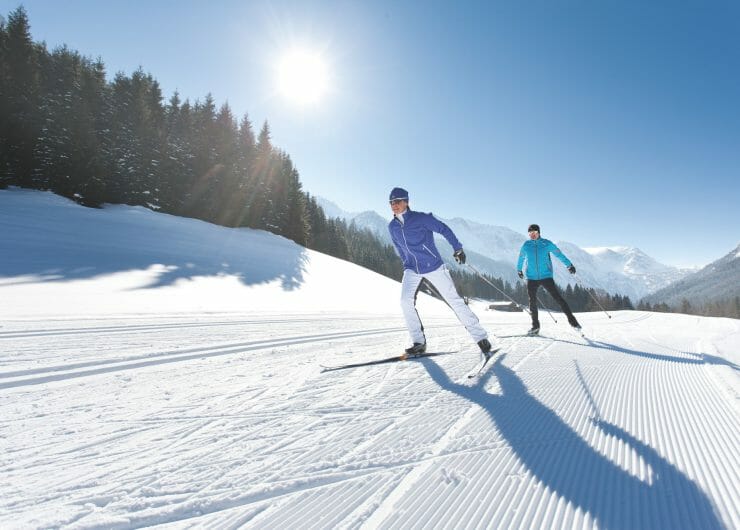 Two cross-country skier skating in the sun