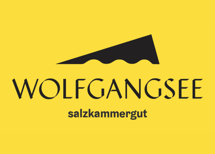 logo_wolfgangsee_schwarz-gelb_resized Yellow background with black text WOLFGANGSEE Salzkammergut and a triangular wave-like logo above.