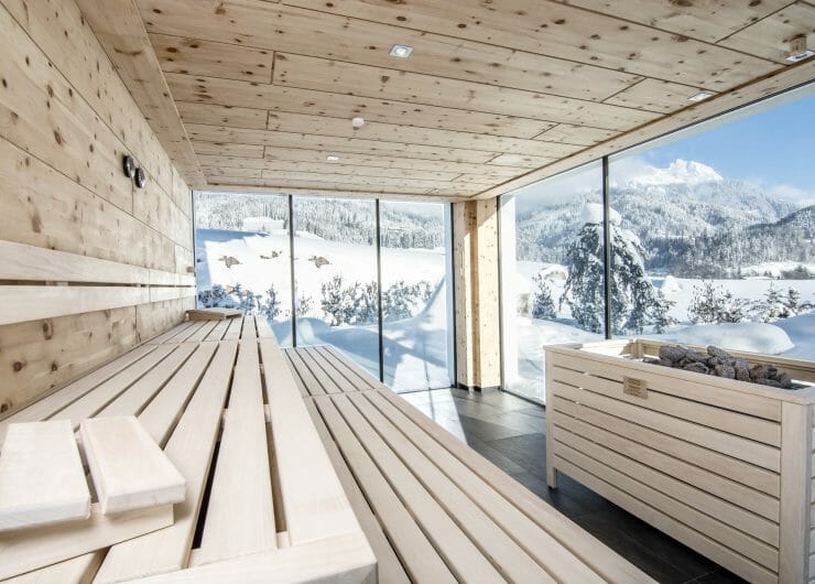 Empty stone pine sauna with a great view into the snowy winter landscape