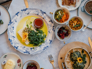 A table set with assorted colourful dishes offers a delightful culinary experience of cheese, salad, and sauces.