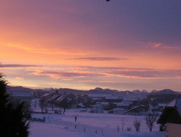 a picture in the evening of cottages covered with snow