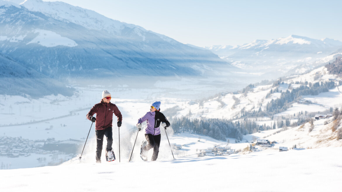 (c)Mathäus Gartner Two people snowshoeing uphill in Hohe Tauern National Park with scenic peaks and a valley in the background. (Enlarged view)