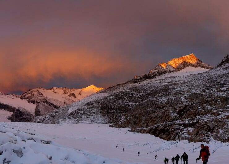 Eine Gruppen von Skitourengehern auf dem Weg nach oben im herrlichen Licht des Sonnenuntergangs.