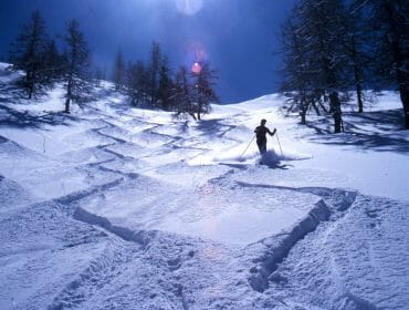 a man riding a snowboard down a snow covered slope