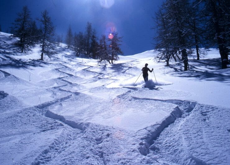 a man riding a snowboard down a snow covered slope