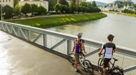 ©SalzburgerLand Tourismus - short break with beautiful view, 2 cyclists on bridge over Salzach - Tauern cycle path